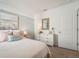 Serene bedroom featuring a bed with a white textured comforter, dresser, and soothing coastal art at 32708 Winterwood Blvd, Wesley Chapel, FL 33543
