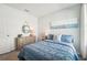 Inviting bedroom showcases a bed with patterned bedding, dresser, and a calming coastal art theme at 32708 Winterwood Blvd, Wesley Chapel, FL 33543