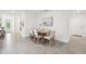 Dining room features rustic table with seating for six, adjacent to the hallway and kitchen at 32708 Winterwood Blvd, Wesley Chapel, FL 33543