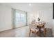 Bright dining room features tile floors, large window, and rustic wooden table set for six at 32708 Winterwood Blvd, Wesley Chapel, FL 33543