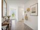 Inviting hallway with neutral tile floors and stylish decor leading to the home's bright interior at 32708 Winterwood Blvd, Wesley Chapel, FL 33543