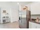 Kitchen with stainless steel refrigerator, white cabinets and wine rack for storage at 32708 Winterwood Blvd, Wesley Chapel, FL 33543
