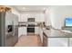 Modern kitchen with stainless steel appliances, white cabinets, and ample counter space for cooking at 32708 Winterwood Blvd, Wesley Chapel, FL 33543