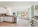 Open concept kitchen with stainless steel appliances, white cabinetry and a view into the living area at 32708 Winterwood Blvd, Wesley Chapel, FL 33543