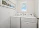 Laundry room featuring a side-by-side washer and dryer with wall art and window at 32708 Winterwood Blvd, Wesley Chapel, FL 33543