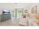 Bright living room with neutral tones, tile flooring, and sliding glass doors to the backyard at 32708 Winterwood Blvd, Wesley Chapel, FL 33543