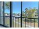 Serene view from a screened balcony overlooking a landscaped area with a walkway and community buildings at 3281 Beneva Rd # 202, Sarasota, FL 34232