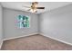 Cozy bedroom featuring neutral carpeting, a ceiling fan, and a window view at 3281 Beneva Rd # 202, Sarasota, FL 34232