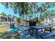 Outdoor community grilling area with picnic table, barbeque, water view, and landscaping at 3281 Beneva Rd # 202, Sarasota, FL 34232