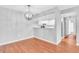 Bright dining area features hardwood floors, a modern light fixture, and views to kitchen at 3281 Beneva Rd # 202, Sarasota, FL 34232