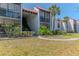 Building exterior showcasing balconies, tile roofing, garden landscaping, and multiple floors of residences at 3281 Beneva Rd # 202, Sarasota, FL 34232