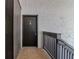 Condo hallway with dark door, textured walls and wood railing at 3281 Beneva Rd # 202, Sarasota, FL 34232