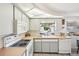 Bright kitchen featuring white appliances and cabinets, and a unique lighting fixture at 5616 Riddle Rd, Holiday, FL 34690