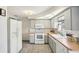 Bright kitchen featuring white appliances, white cabinets, and tile flooring at 5616 Riddle Rd, Holiday, FL 34690