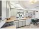 Well-lit kitchen featuring bright appliances, a double sink, and an adjacent breakfast nook at 5616 Riddle Rd, Holiday, FL 34690