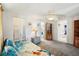 Bedroom with neutral walls, a ceiling fan, and access to an ensuite bathroom, offering comfort and convenience at 5616 Riddle Rd, Holiday, FL 34690