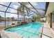 Sparkling screened-in pool overlooking the waterfront; outdoor living at its finest at 5616 Riddle Rd, Holiday, FL 34690