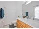 Well-lit bathroom featuring a walk-in shower, a vanity with a quartz countertop, and white tiled walls at 7001 Cohasset Cir, Riverview, FL 33578