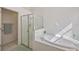 Bright bathroom features a white tiled whirlpool tub and glass-enclosed shower at 7001 Cohasset Cir, Riverview, FL 33578