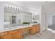 Bright bathroom featuring a double vanity, tiled floor, large mirror and neutral color palette at 7001 Cohasset Cir, Riverview, FL 33578