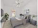 Staged bedroom with neutral decor, ceiling fan, and large window provides ample light at 7001 Cohasset Cir, Riverview, FL 33578