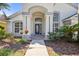 Close-up of the front entrance, highlighting the decorative door and manicured landscaping at 7001 Cohasset Cir, Riverview, FL 33578