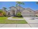 Charming single-story home featuring a lush front yard and a three-car garage at 7001 Cohasset Cir, Riverview, FL 33578
