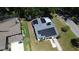 Aerial view showcasing a house with solar panels and a well-manicured lawn, highlighting energy efficiency at 701 W Idlewild Ave, Tampa, FL 33604