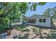 Backyard showing a quaint home with a screened-in porch and lush greenery, providing a peaceful outdoor space at 701 W Idlewild Ave, Tampa, FL 33604