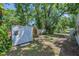 Backyard featuring lawn, mature trees and white storage shed at 701 W Idlewild Ave, Tampa, FL 33604