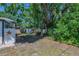 Large backyard featuring mature trees, lawn and storage shed at 701 W Idlewild Ave, Tampa, FL 33604