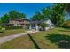 Landscaped lawn featuring a white home with solar panels and a brick pathway at 701 W Idlewild Ave, Tampa, FL 33604