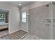 Bathroom boasting a glass-enclosed shower, tiled walls, and wood-look tile flooring, offering both style and function at 7417 Sungold Meadow Ct, Apollo Beach, FL 33572