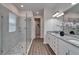 Modern bathroom with double sinks, granite countertops, and a stylish tiled shower with glass door at 7417 Sungold Meadow Ct, Apollo Beach, FL 33572