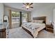 Bright bedroom featuring a wood-framed bed, soft carpet, and plenty of natural light from the windows at 7417 Sungold Meadow Ct, Apollo Beach, FL 33572