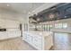 Open-concept great room featuring modern lighting and a large island with ample counter space at 7417 Sungold Meadow Ct, Apollo Beach, FL 33572