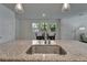 Kitchen island sink area with granite countertops, faucet, and a view of the dining room with natural light at 7417 Sungold Meadow Ct, Apollo Beach, FL 33572