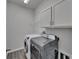 Well-lit laundry room with a washer, dryer, cabinet storage, and tile flooring at 7417 Sungold Meadow Ct, Apollo Beach, FL 33572