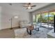 Bright living room with tile floors, a ceiling fan, and sliding glass doors to the backyard at 7417 Sungold Meadow Ct, Apollo Beach, FL 33572