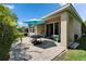 Charming stone patio with outdoor furniture, a shade umbrella, and private backyard with lush landscaping at 7417 Sungold Meadow Ct, Apollo Beach, FL 33572