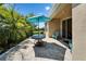 Comfortable stone patio with outdoor table, chairs, large shade umbrella, and a manicured lawn at 7417 Sungold Meadow Ct, Apollo Beach, FL 33572