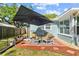 Cozy backyard patio with an umbrella providing shade for outdoor seating at 7747 90Th N Way, Seminole, FL 33777