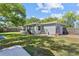 Well-maintained backyard with lush lawn, mature trees, and a patio area, perfect for outdoor enjoyment at 7747 90Th N Way, Seminole, FL 33777