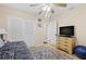 Bright bedroom features a closet, ceiling fan, and a chest of drawers with a TV at 7747 90Th N Way, Seminole, FL 33777