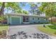 Charming single-story home with blue siding, a well-manicured front lawn, and a convenient circular driveway at 7747 90Th N Way, Seminole, FL 33777