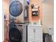 Convenient laundry area with stacked washer and dryer and sink with storage underneath at 7747 90Th N Way, Seminole, FL 33777