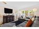 Comfortable living room showcasing a large sectional, a wooden cabinet, and abundant natural light at 7747 90Th N Way, Seminole, FL 33777