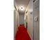 Hallway with a red floor and neutral colored walls connecting to other rooms at 7939 Pine Dr # 7939, Temple Terrace, FL 33637
