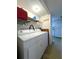 Well-lit laundry room equipped with a washer, dryer, and storage shelving at 7939 Pine Dr # 7939, Temple Terrace, FL 33637
