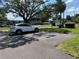 A car sits in a parking spot surrounded by lush grass and mature trees, creating a tranquil atmosphere at 7939 Pine Dr # 7939, Temple Terrace, FL 33637